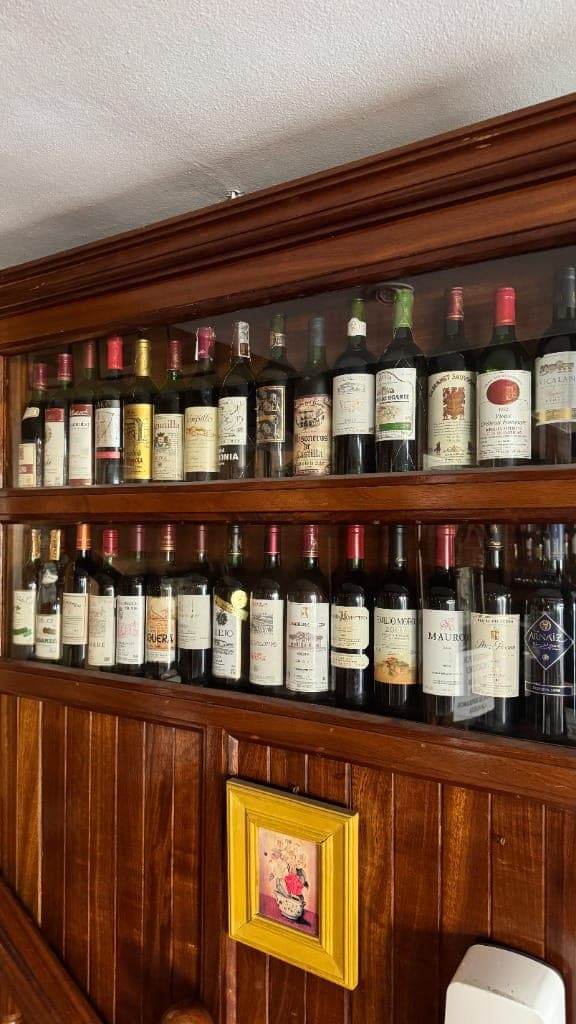 Vitrina de madera con vinos históricos y grandes añadas
